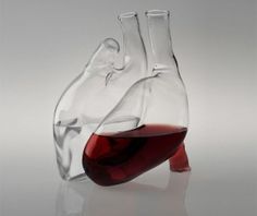 a heart shaped wine decanter with red liquid in it's beaker