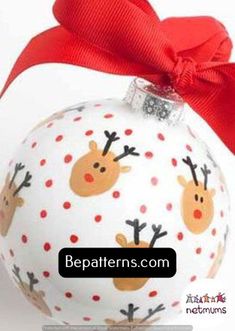 a white ornament with reindeers on it and a red ribbon around the top