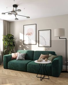 a living room with green couches and pictures on the wall