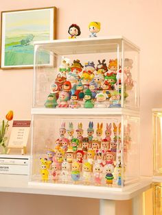 there are many toy figurines on display in the glass case above the desk