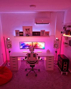 a computer desk with two monitors and speakers on it in front of a purple light