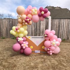 a bunch of balloons are in the shape of flowers on top of a cardboard box