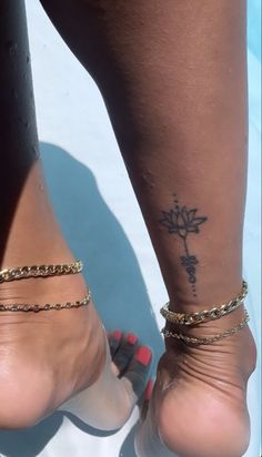 a close up of a person's foot with a cross tattoo on her ankle