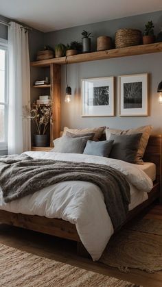 a large bed sitting in a bedroom next to a window with potted plants on top of it