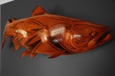 a carved wooden fish hanging on the wall