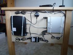 an electronic device is plugged into the back of a table with wires and cords