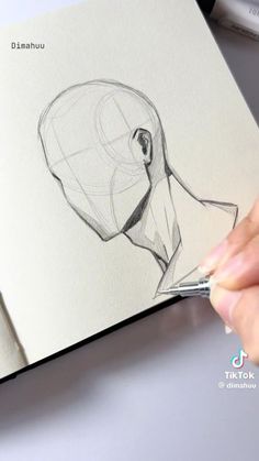 a person is drawing on paper with a pen