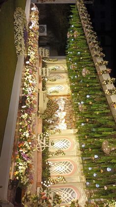 an elaborately decorated garden at night with flowers and greenery on the side walk