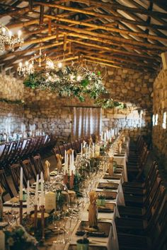 a long table is set up with candles and place settings for an elegant wedding reception