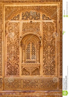 an intricate carved wall in the alhambra palace