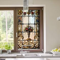 a kitchen with a sink, window and counter top in front of an open door