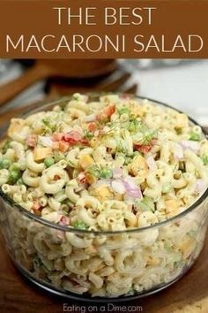 macaroni salad in a glass bowl on top of a wooden cutting board with text overlay