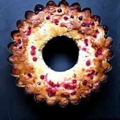 a cake that is sitting on top of a black surface with berries in it and the bottom crust missing