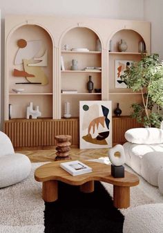 a living room filled with white furniture and lots of bookshelves on the wall