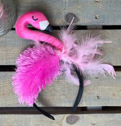 a pink flamingo headband with feathers on it