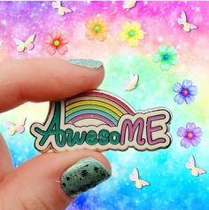 someone is holding up a pin with the word awesome on it and butterflies in the background