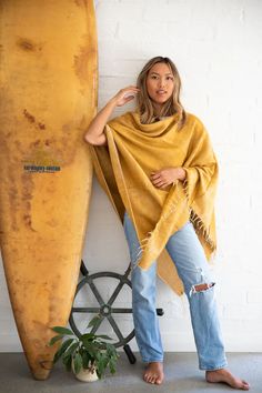 This honey-hued poncho is handwoven in Nepal on majestic wooden looms using a soft, unique yarn and finished with perfectly twisted tassels. Sewn in Western Australia, this piece is perfect for chilly mornings or cool beach evenings. It's easy to style this poncho. Wear it with the v-neck at the front or diagonal for a different look. One size fits most. Approximate size overall is 30 x 74 inches. Wash by hand in cold water and dry with care. Bohemian One-size Handwoven Cape, Bohemian Handwoven One-size Cape, One Size Tasseled Shawl For The Beach, Beach Shawl With Tassels, Beach Shawl With Tassels One Size, Cozy One Size Poncho For Beach, Fall Beach Cape Shawl, One Size Beach Shawl With Fringe, One Size Poncho For Beach In Fall