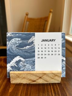 a desk calendar sitting on top of a wooden block