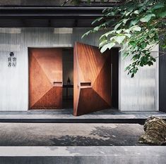 two wooden doors open in front of a building