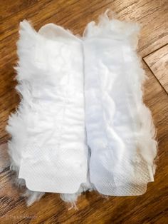 two pairs of white gauze sitting on top of a wooden floor