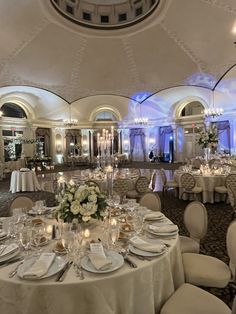 a banquet hall with tables and chairs covered in white linens