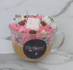 a cup filled with lots of candy and marshmallows on top of it