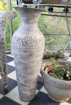 a large vase sitting on top of a table next to two planters