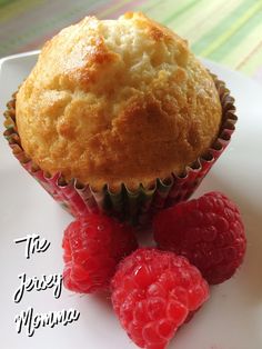 a muffin and some raspberries on a white plate with the words the busy morning