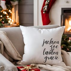 a white pillow sitting on top of a couch next to a christmas tree