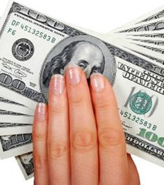 a woman's hand holding money in front of white background