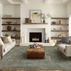 a living room with two couches and a coffee table in front of a fireplace