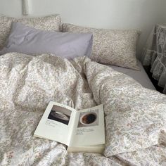 an open book sitting on top of a bed