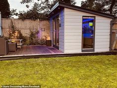 a small backyard shed is lit up with blue lights on the front and side doors