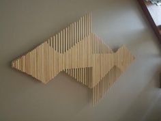 an arrow made out of wood sticks hanging on the wall