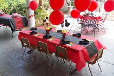 an outdoor party with red balloons and black table cloths