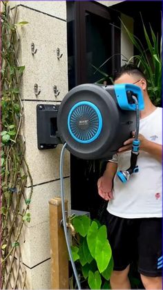 a man standing next to a wall with a blow dryer on it