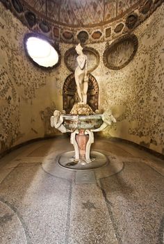 a statue is in the middle of a room with an intricately decorated wall and ceiling