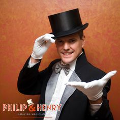 a man wearing a top hat and gloves holding his hand up to the side while smiling