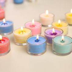 many different colored candles sitting on top of a table