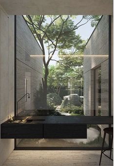 the interior of a modern house with trees and plants in the window, as well as an outdoor sink