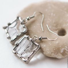 the earrings are made out of silver wire and have clear crystal cubes on them