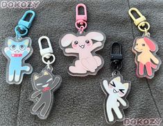 four different key chains with cartoon animals on them, one has a cat and the other has a dog