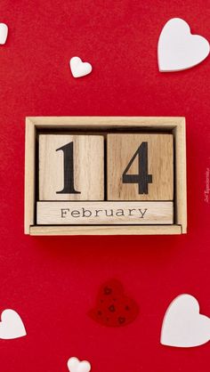 a wooden calendar with the date 14th february on it and hearts scattered all around them