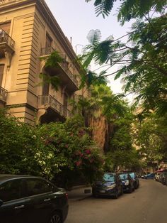 cars are parked on the street in front of an apartment building