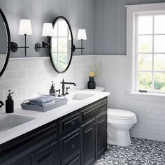 a bathroom with two sinks, mirrors and a toilet in front of a large window