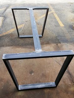 two metal frames sitting in the middle of a parking lot with no one around them