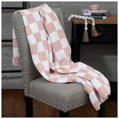 a pink and white checkered blanket sitting on top of a chair next to a table