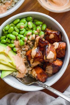 a bowl filled with meat, peas and rice