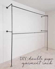 an empty room with white walls and black metal pipe work on the wall, along with text that reads diy double pipe garment rack