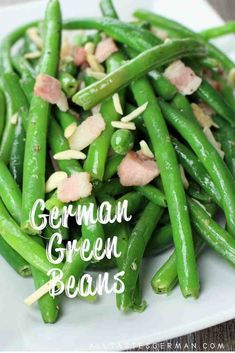 a white plate topped with green beans covered in bacon and seasoning next to the words, german green beans